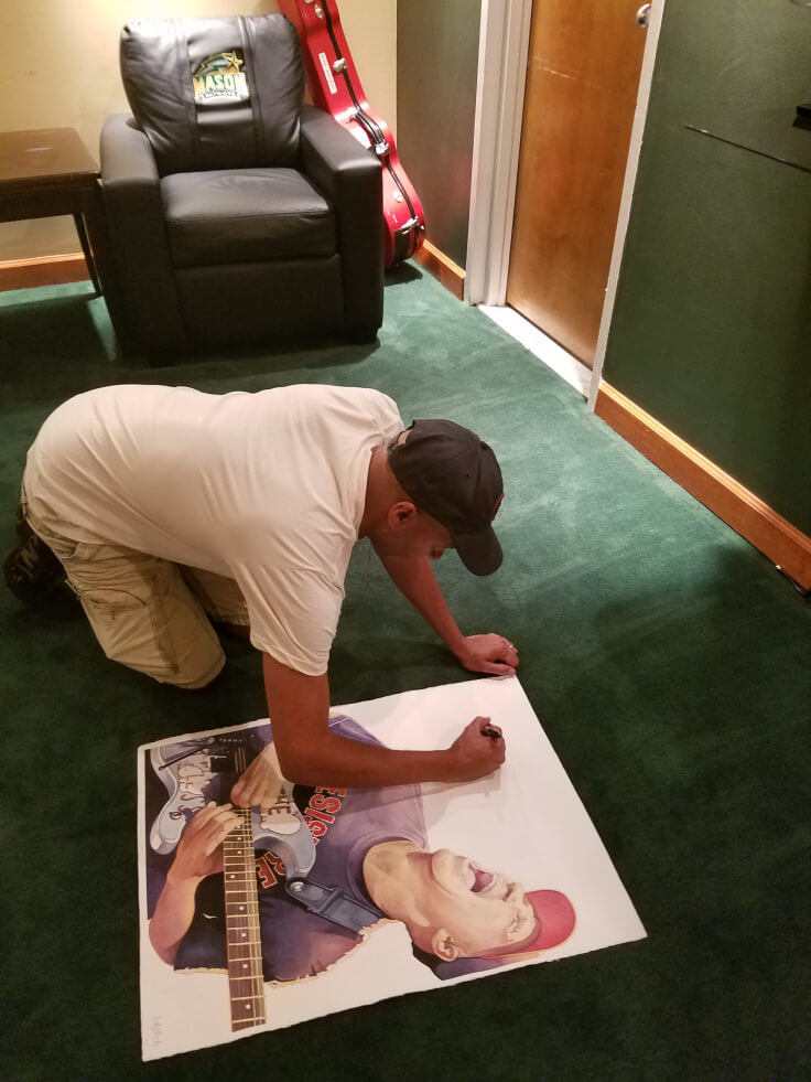 Tom Morello signing the original watercolor – Eagle Bank Arena, George Mason University